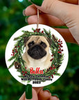 Custom ceramic Christmas ornament with a pug photo, pine wreath, berries, and "My First Christmas" text.