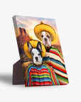 Two dogs in yellow sombreros and colorful striped ponchos on a personalized standing canvas with a desert background.