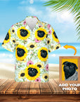 Custom Hawaiian shirt with black pug portraits in sunflowers on a light blue background, shown on a beach.