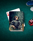 Personalized playing cards featuring a dog's head on an Army veteran's body in camouflage, on a green felt table.