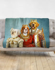Personalized 3-pet royal renaissance portrait blanket on a couch, featuring a white dog, Cavalier King Charles, and Golden Retriever.