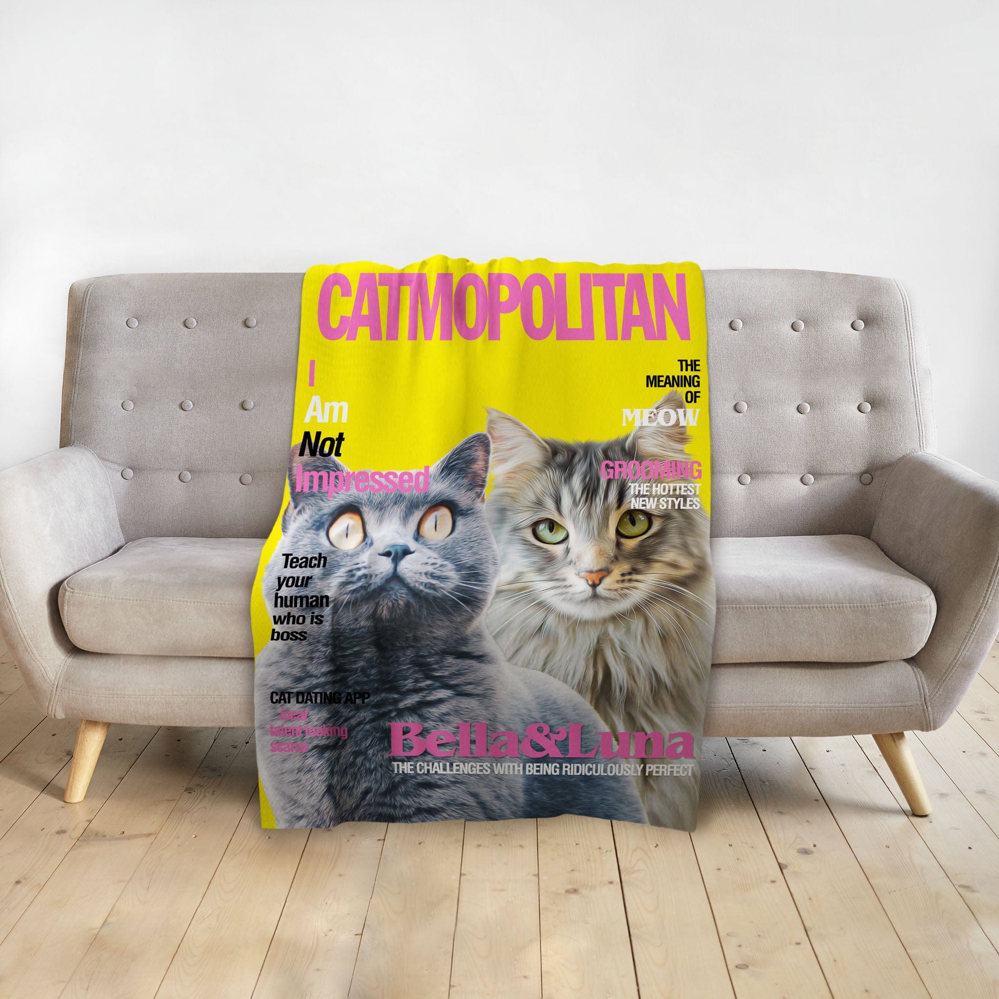 Personalized yellow Catmopolitan blanket featuring custom portraits of two cats, Bella & Luna, on a gray sofa.