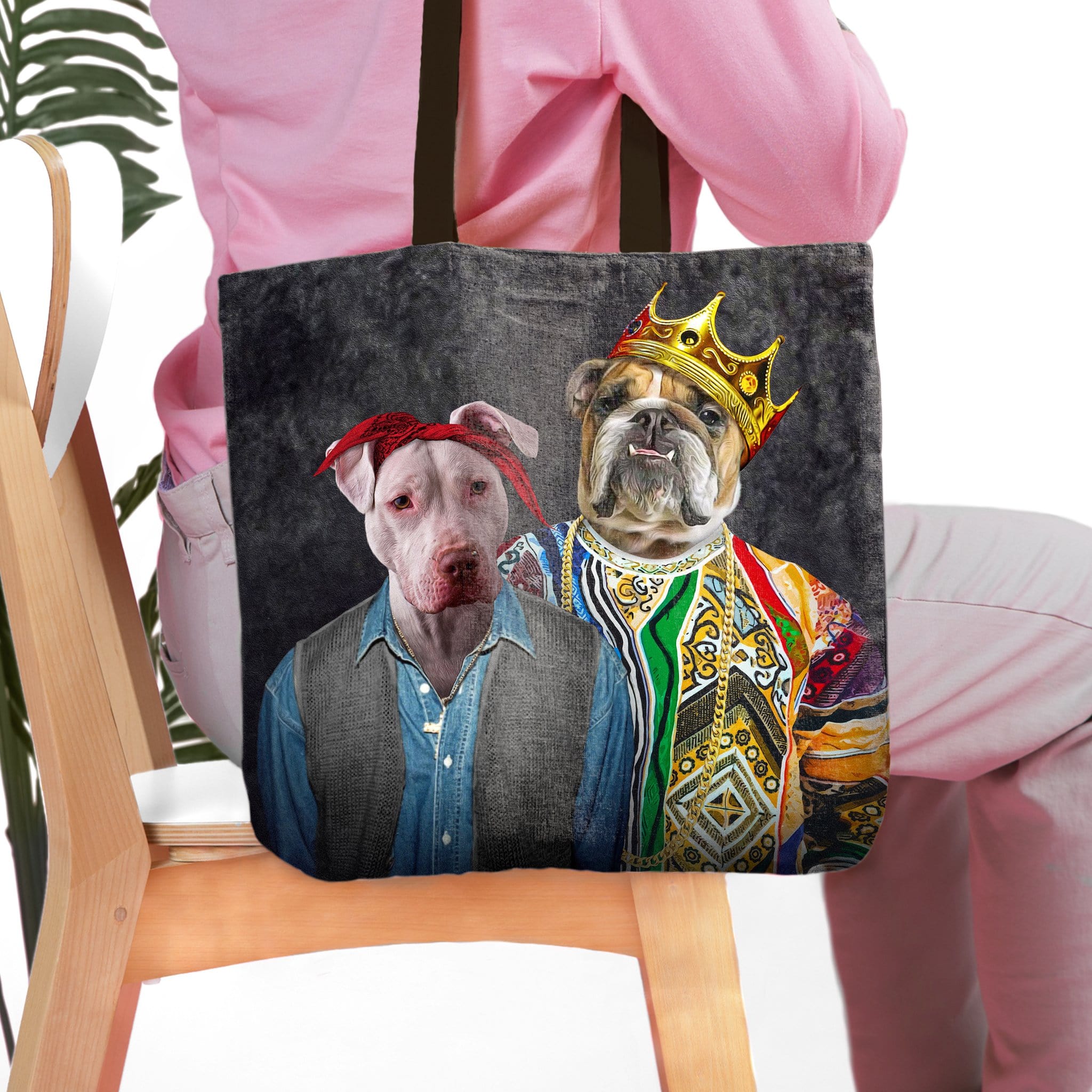 Personalized black tote bag with two pet portraits: a pit bull in a bandana and a bulldog in a crown.