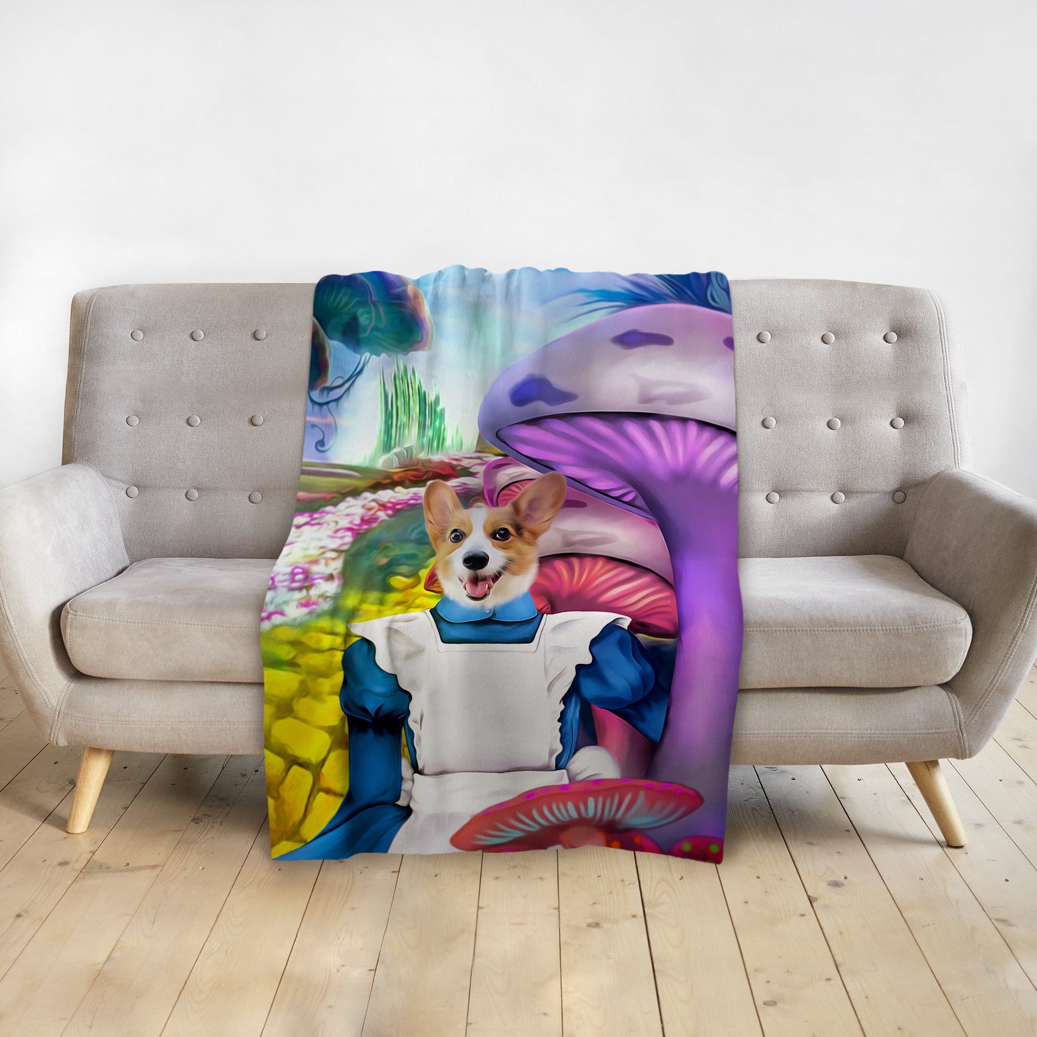 Personalized pet blanket with a corgi in an Alice in Wonderland-style portrait, draped over a gray couch.