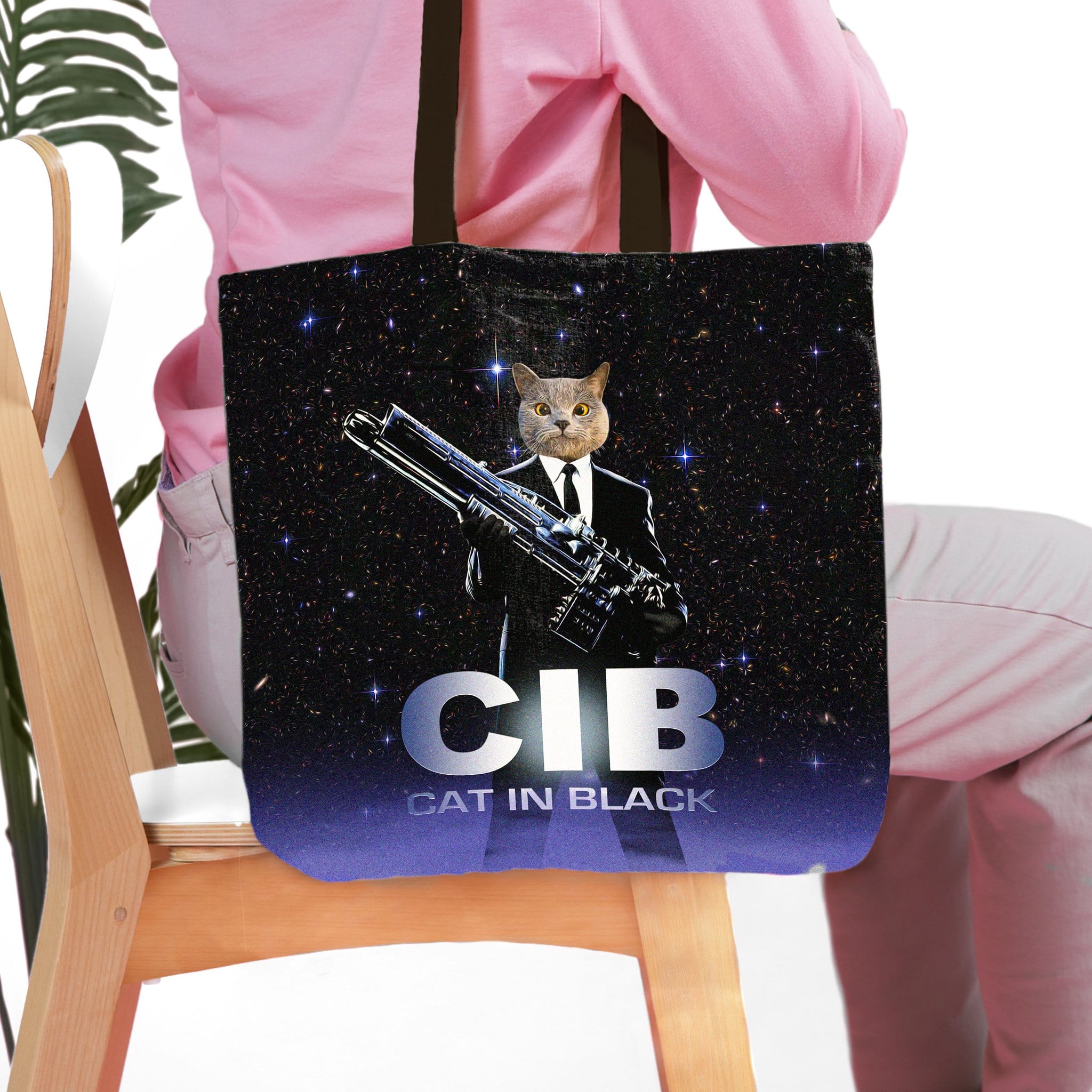 Personalized black tote bag with a custom cat portrait in a suit holding a futuristic gun, "CIB Cat in Black" text.