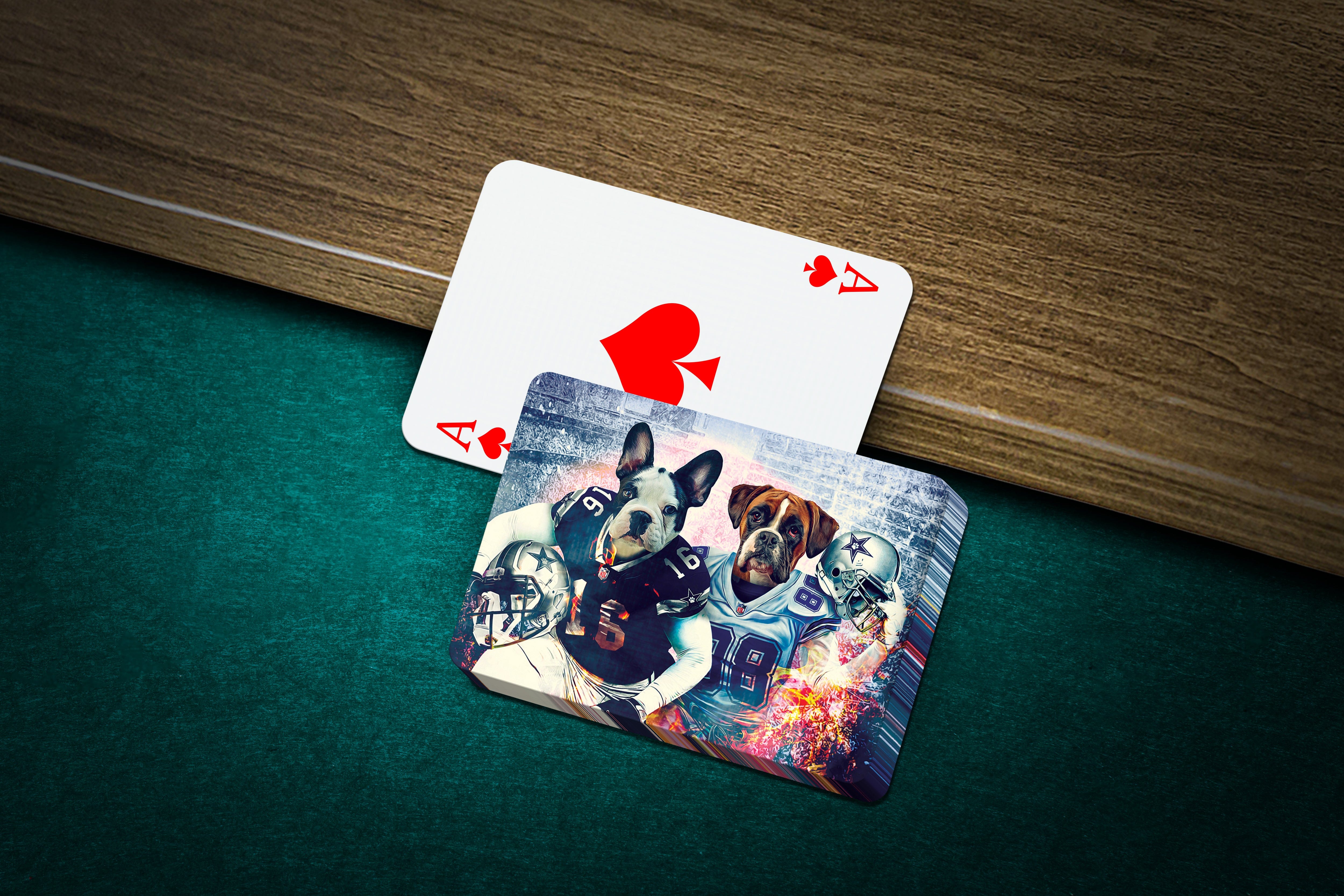 Custom playing cards featuring two personalized dog portraits in football uniforms on a green felt table.