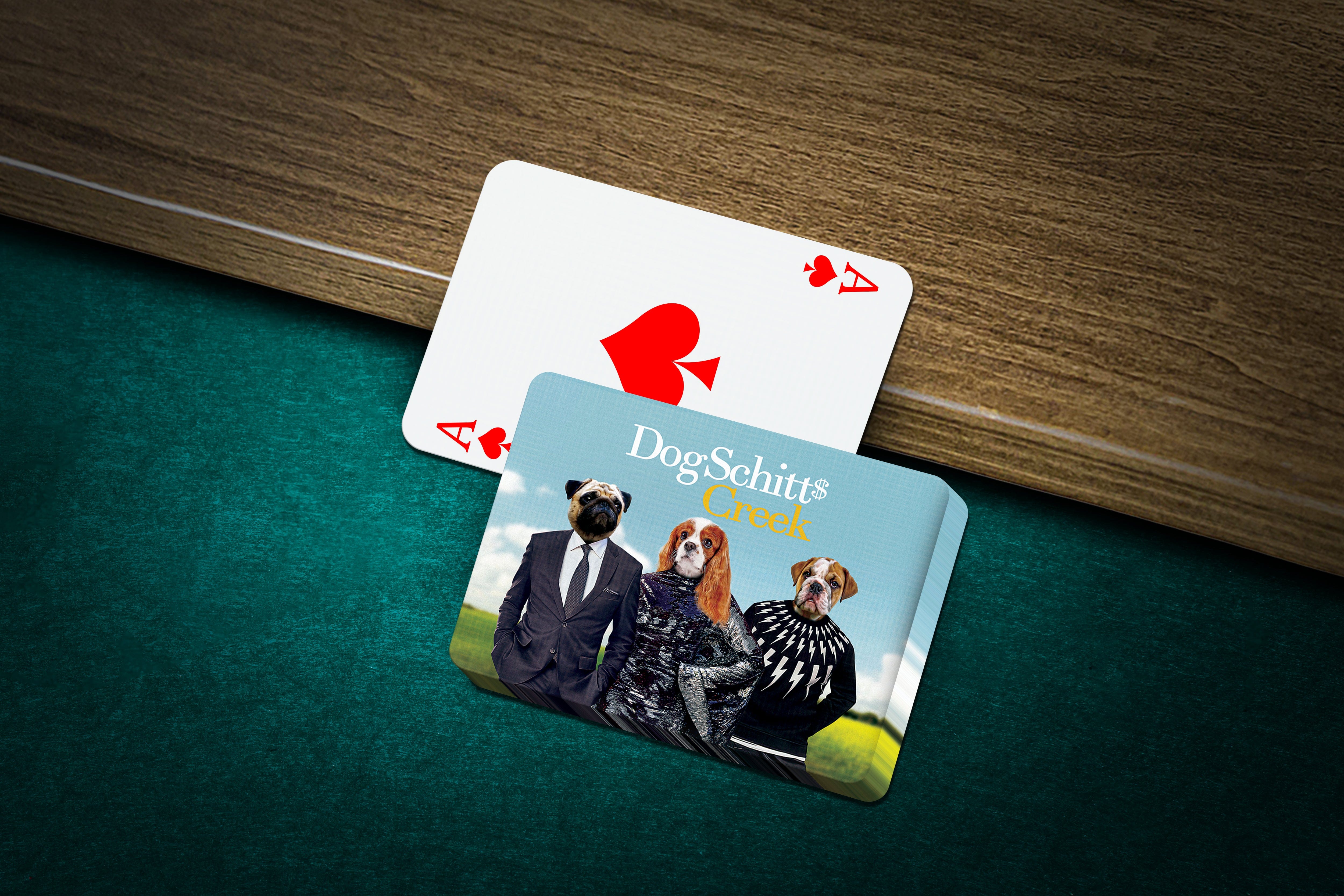 Personalized playing cards featuring three pets in "DogSchitt's Creek" style, on a green felt table.