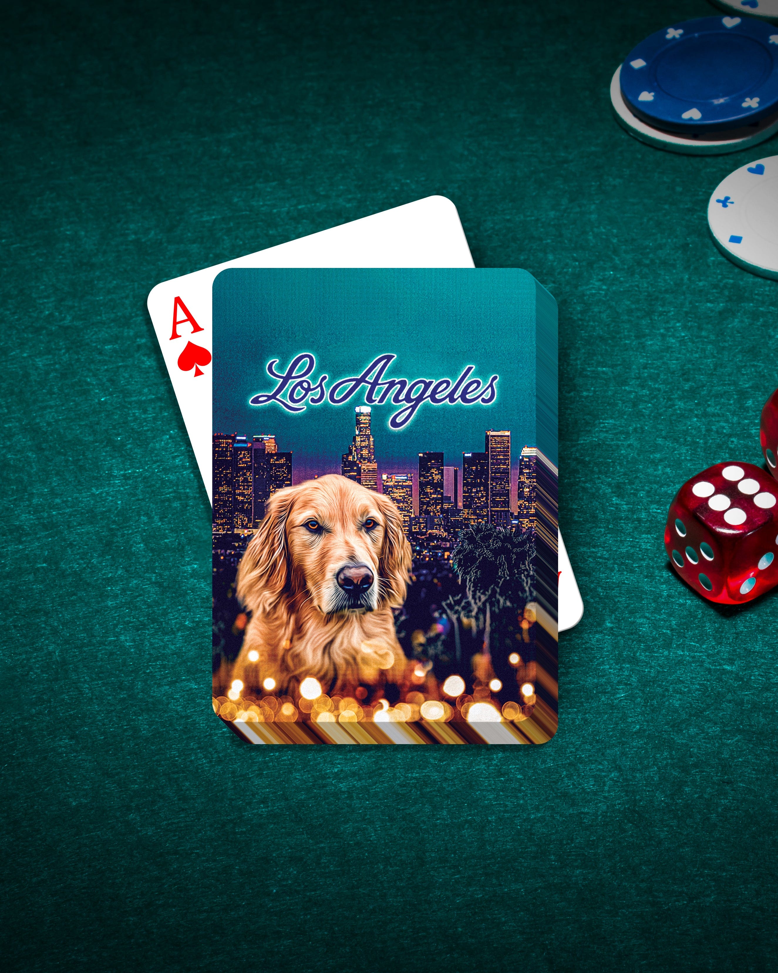 Personalized playing cards featuring a golden retriever portrait over a Los Angeles cityscape, on a green felt table with poker chips and dice.