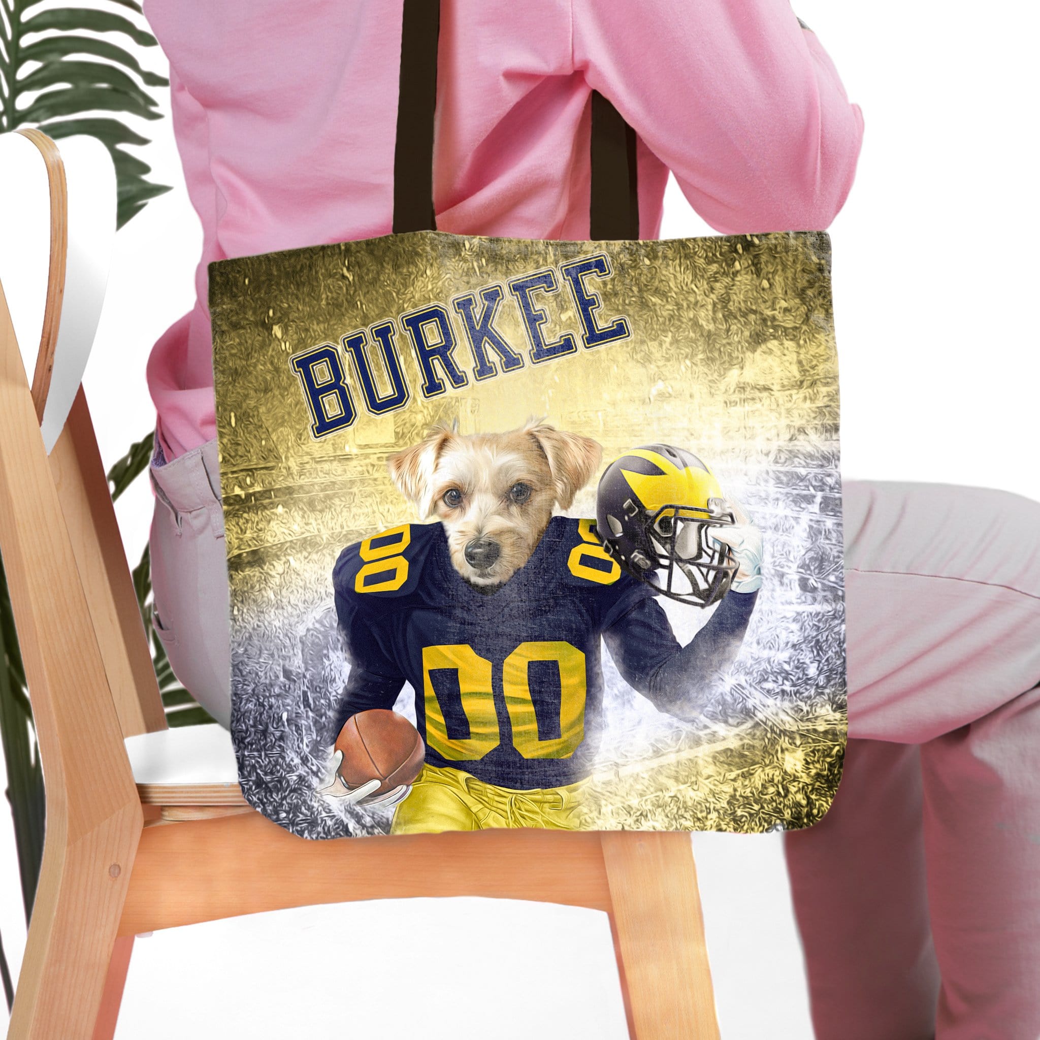 Personalized tote bag with a dog in a Michigan football uniform, holding a helmet and football, with "BURKEE" above.