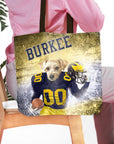 Personalized tote bag with a dog in a Michigan football uniform, holding a helmet and football, with "BURKEE" above.