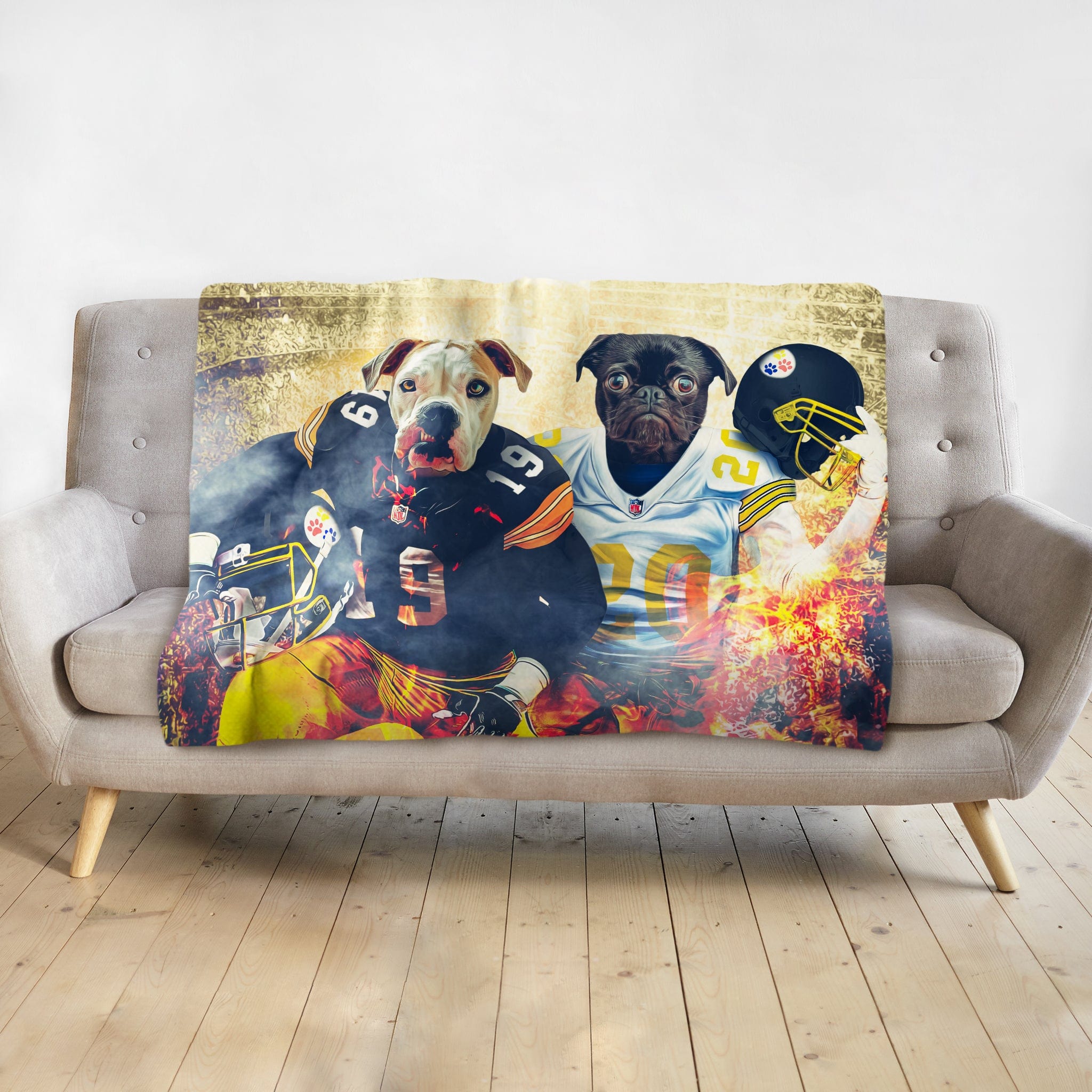 Personalized blanket with two dogs as football players, a white pitbull and a black pug, on a gray couch.