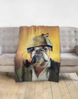 Personalized pet blanket with a bulldog in a Sherlock Doggo portrait, draped over a gray sofa.