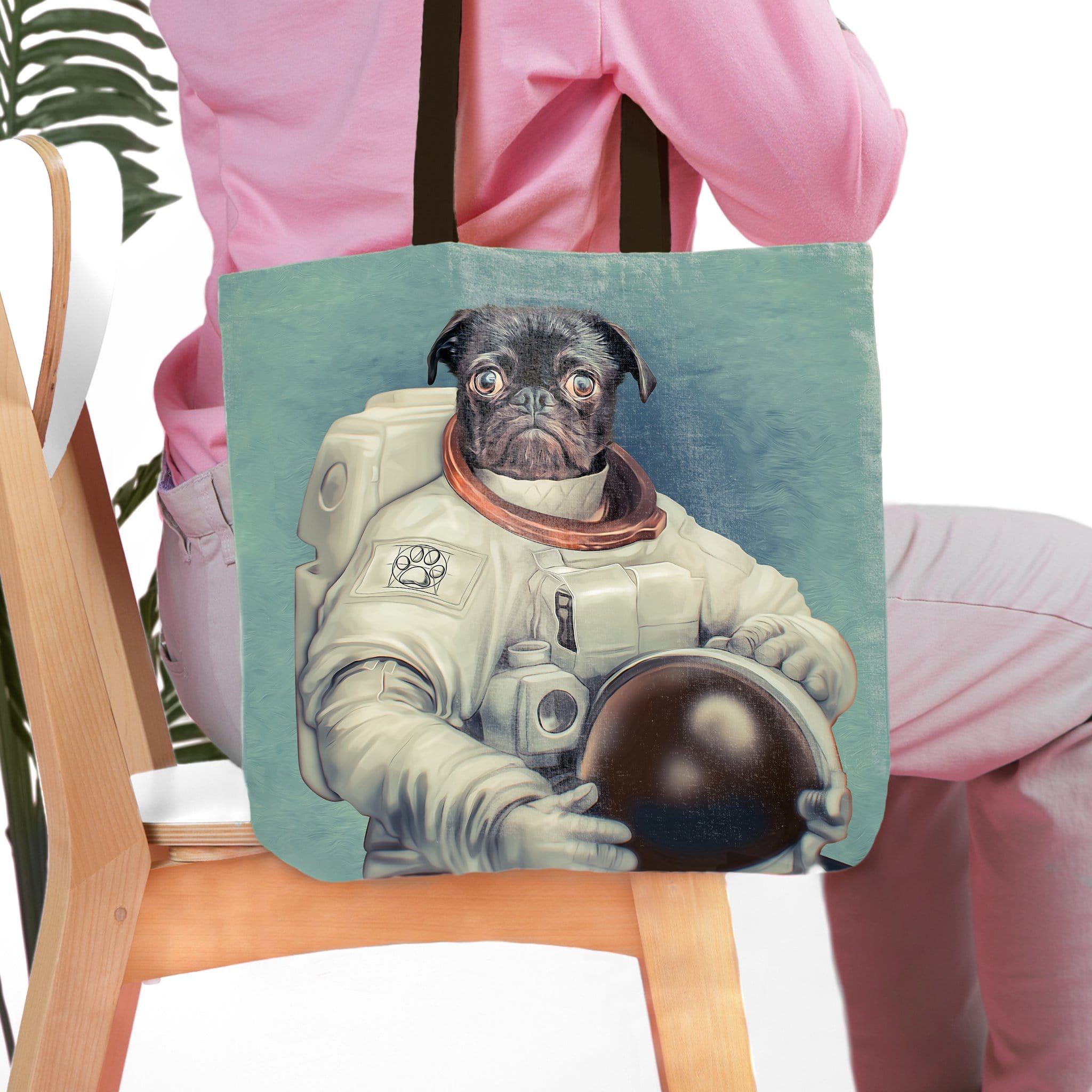 Personalized tote bag featuring a black pug pet portrait as an astronaut on a light blue background.