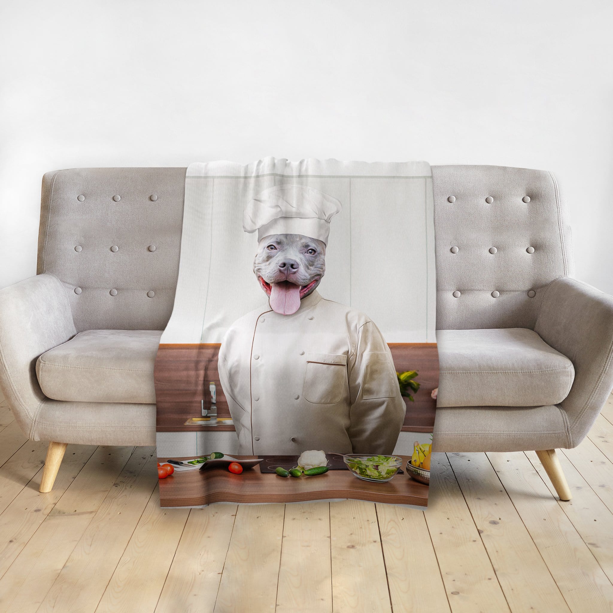 Personalized pet blanket with a pit bull dog portrait dressed as a chef, draped over a gray sofa.