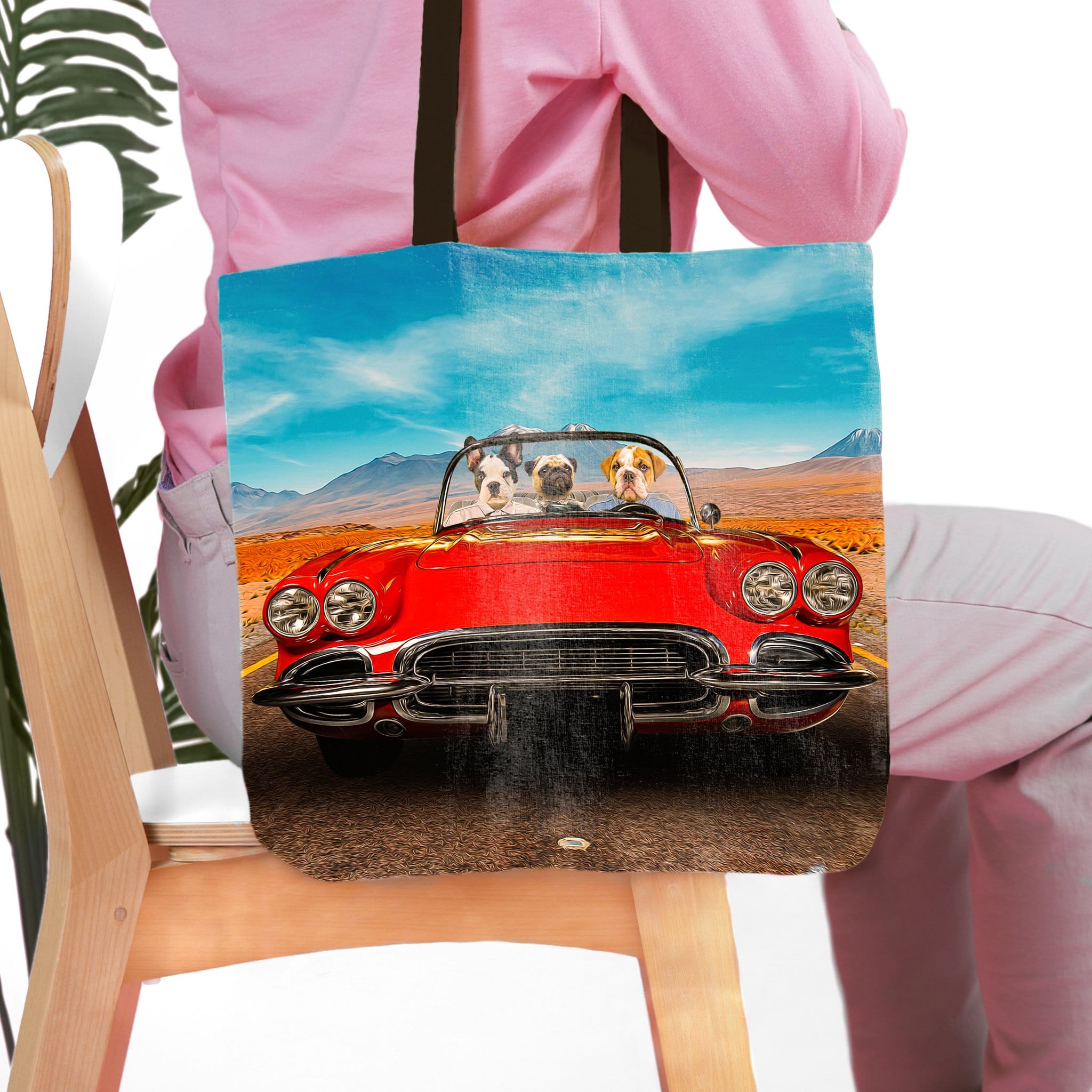 Personalized pet portrait tote bag with three dogs in a red classic car, mountain landscape background.