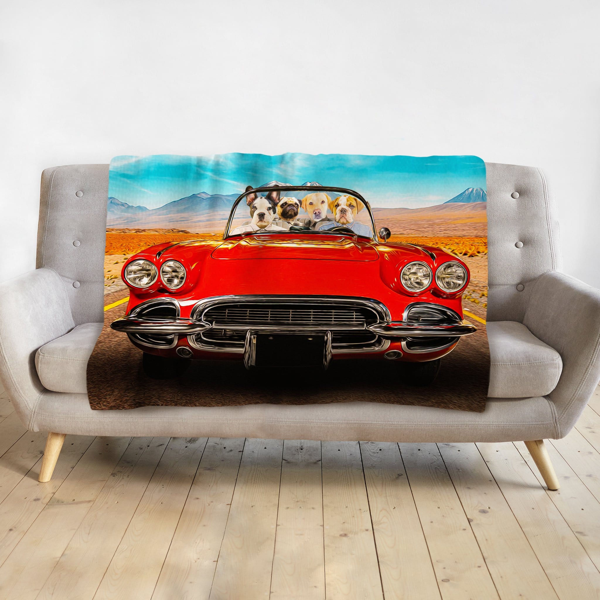Personalized pet portrait blanket featuring four dogs in a red classic car, draped over a gray sofa.