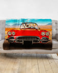 Personalized pet portrait blanket featuring four dogs in a red classic car, draped over a gray sofa.