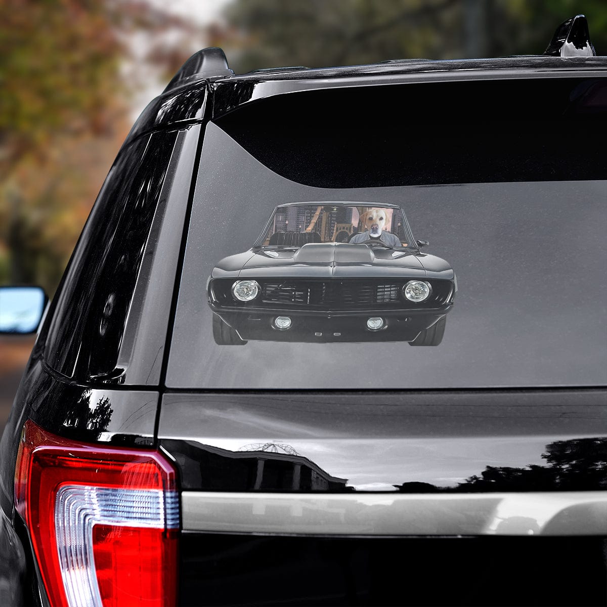 Custom pet decal of a dog driving a black classic car, applied to the rear window of a black SUV.