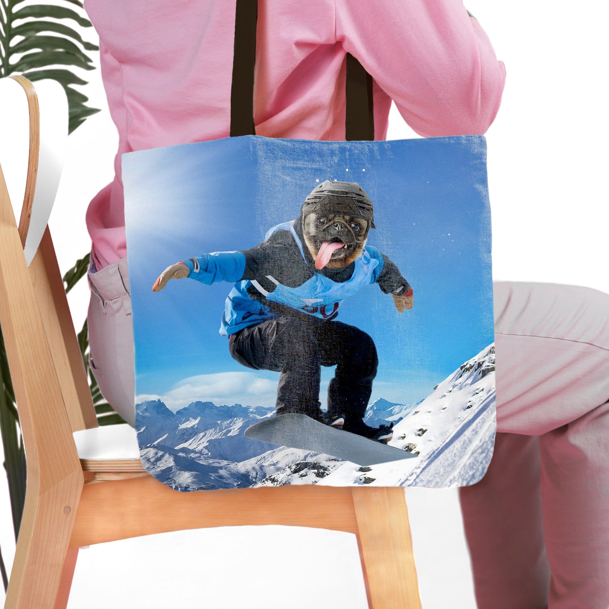 Personalized tote bag with a custom pet portrait of a pug snowboarding on a snowy mountain.