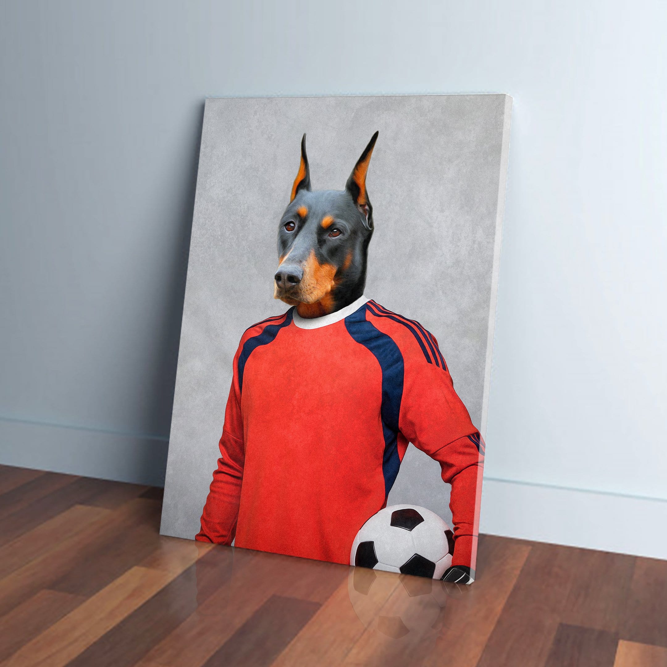 Personalized Doberman pet canvas as a soccer goalie in a red jersey, holding a black and white ball.