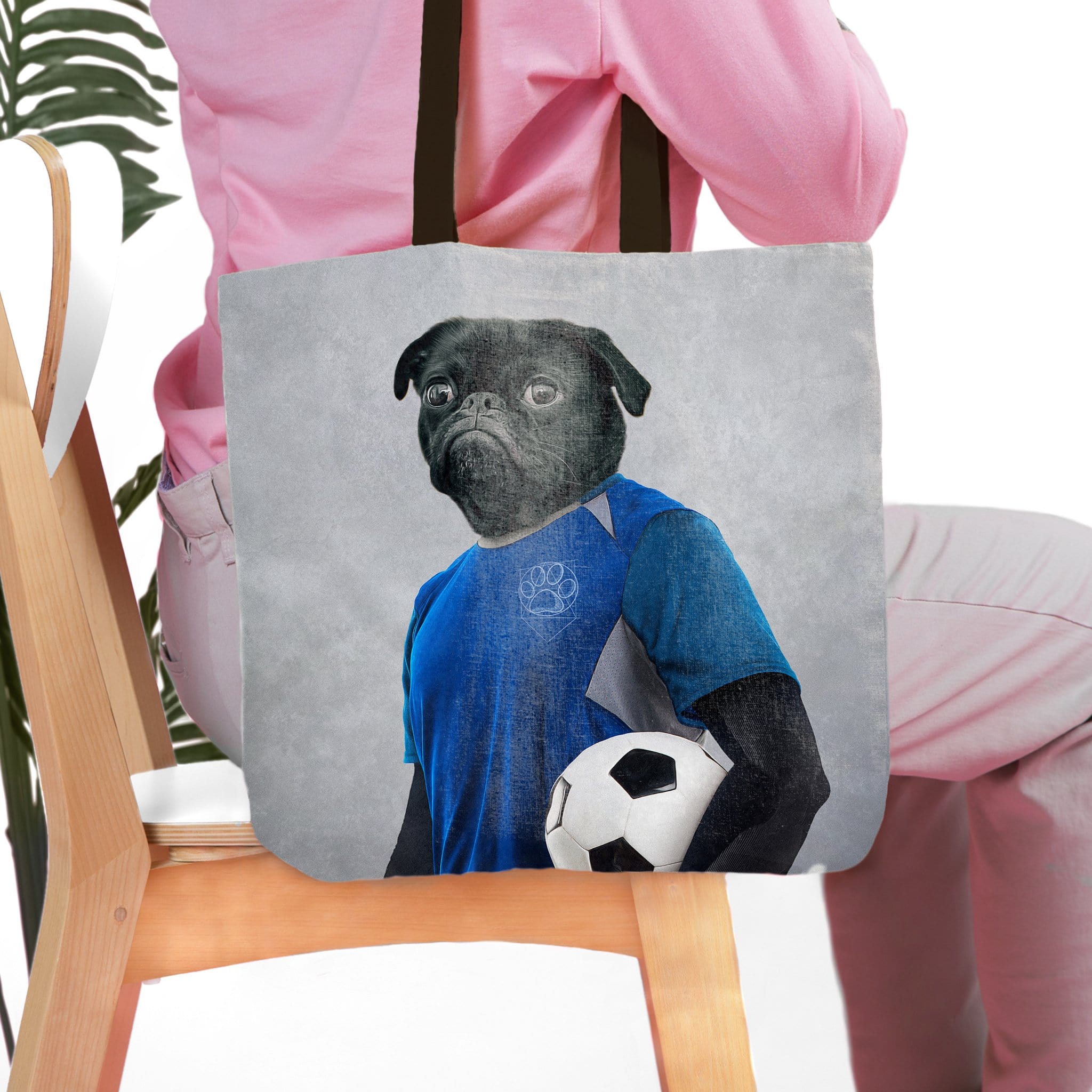 Personalized tote bag with a black pug pet portrait in a blue soccer uniform holding a soccer ball.