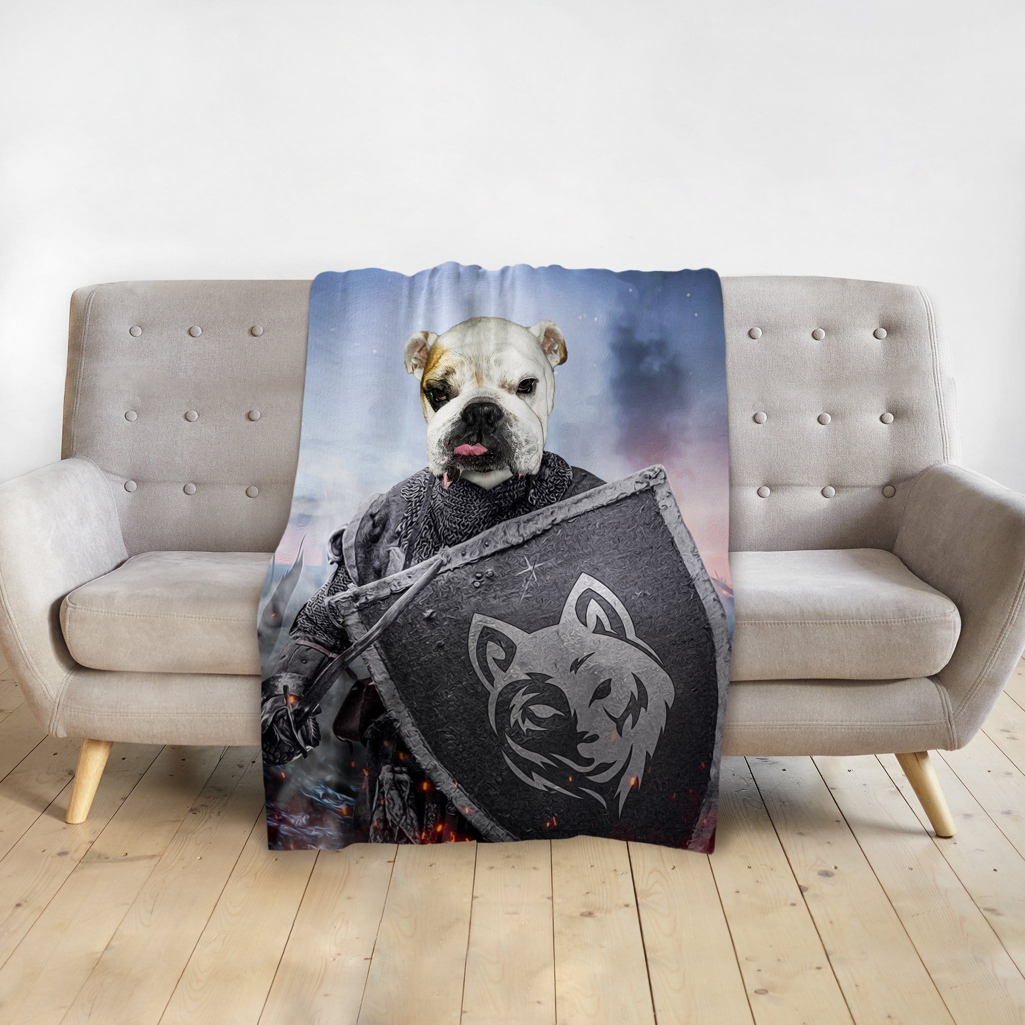 Personalized pet blanket with a bulldog's face on a warrior portrait, draped over a gray couch.
