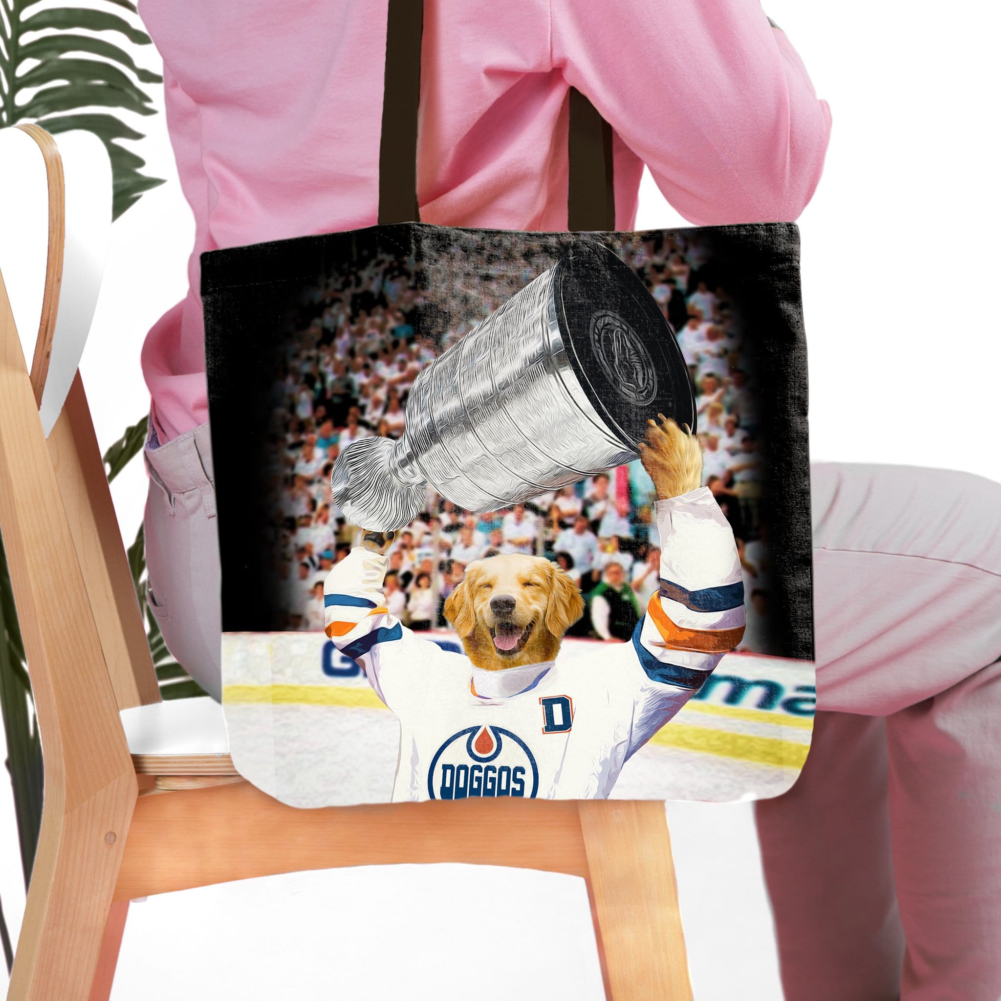 Personalized black tote bag with a golden retriever pet portrait in a hockey jersey holding a trophy.